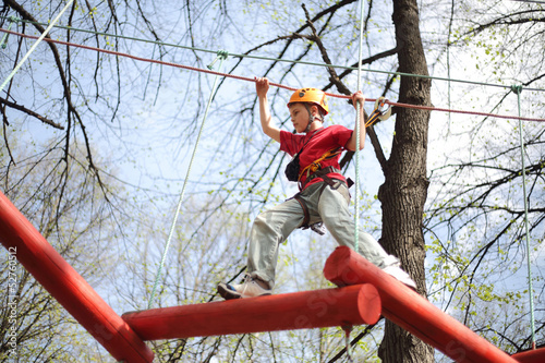 Fototapeta Naklejka Na Ścianę i Meble -  climber skilfully go on suspension bridge in high ropes course.
