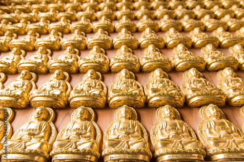 Many of small golden Buddha statue on the wall