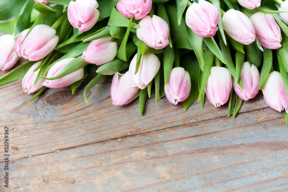 Bunch of pink tulips on wooden background