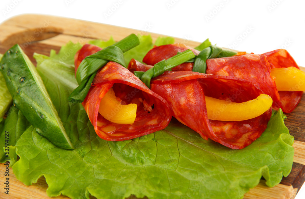 Salami rolls with paprika pieces inside, on wooden board Salami rolls with paprika pieces inside, on wooden board