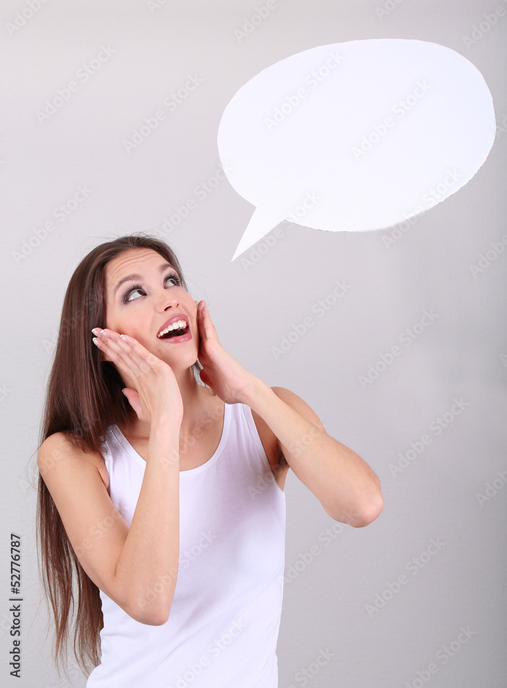 Young pretty woman with empty think bubble on grey background Young pretty woman with empty think bubble on grey background