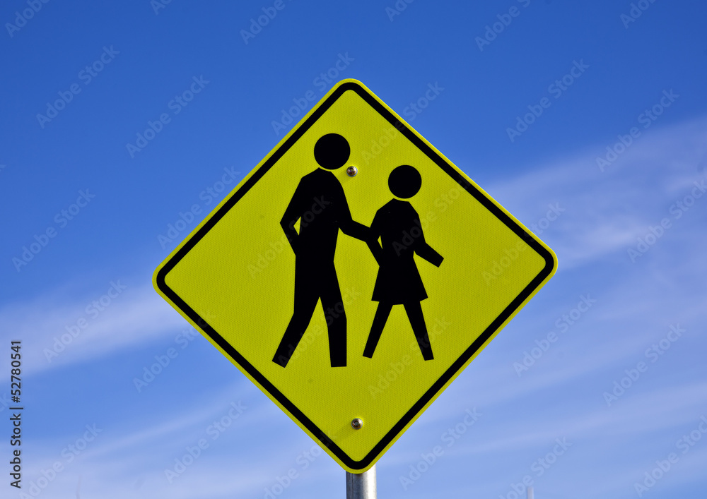 Road sign warns motorists of people crossing Road sign warns motorists of people crossing