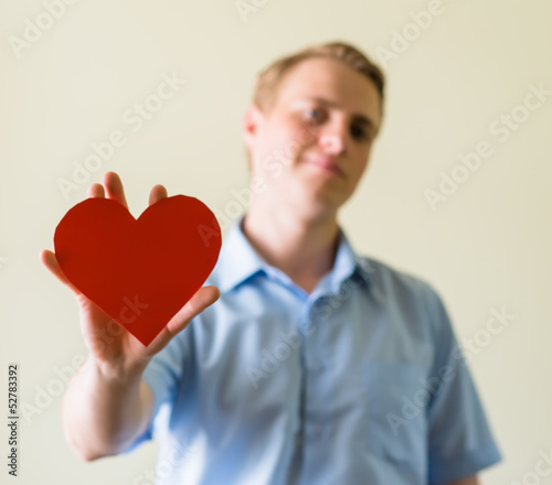 young guy holding a heart © slasnyi