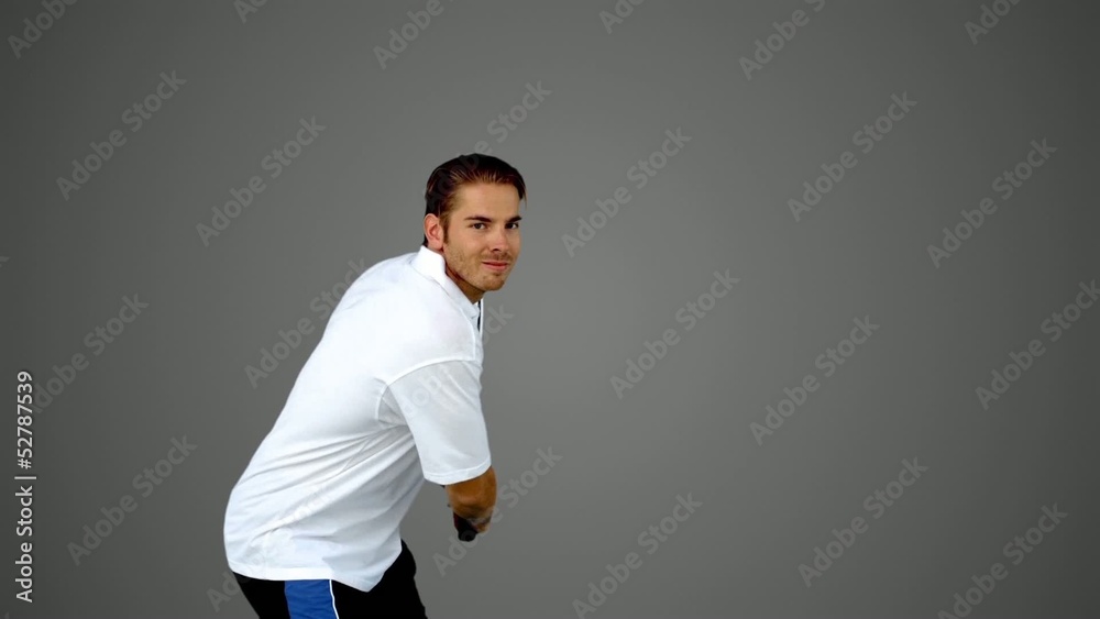 Attractive man playing tennis on grey screen Attractive man playing tennis on grey screen