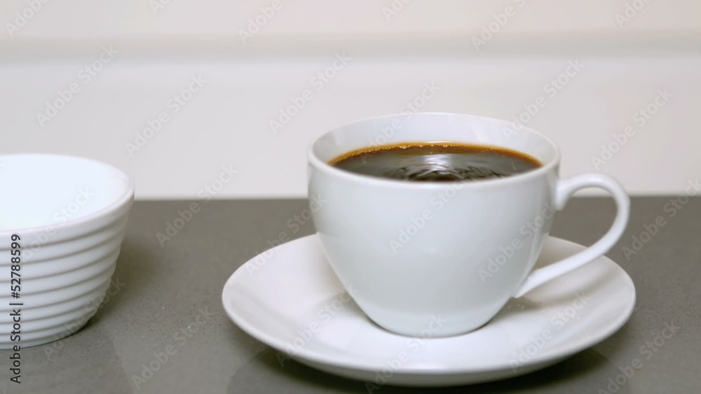 Sugar pouring into cup of coffee Sugar pouring into cup of coffee