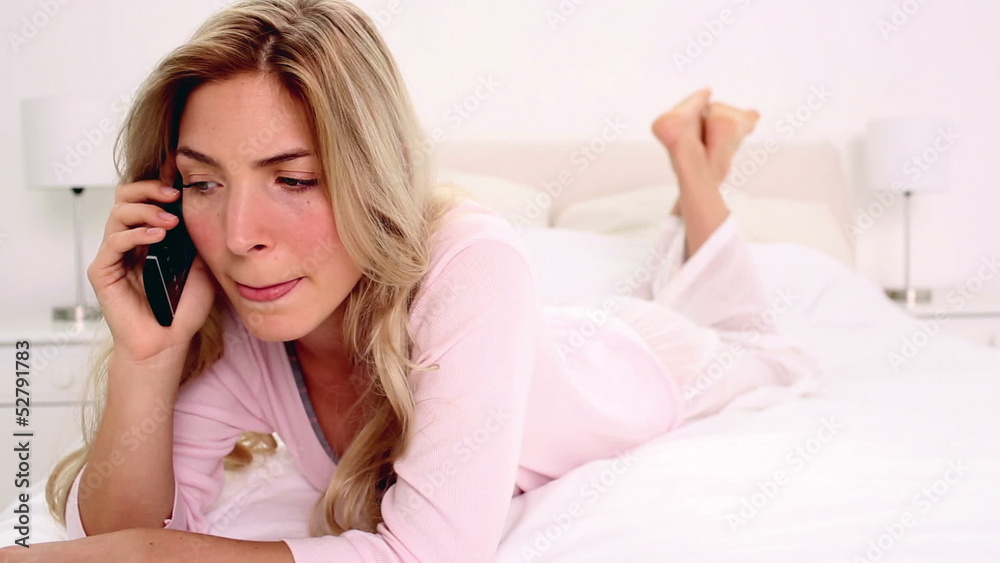 Blonde woman talking on phone in bedroom Blonde woman talking on phone in bedroom