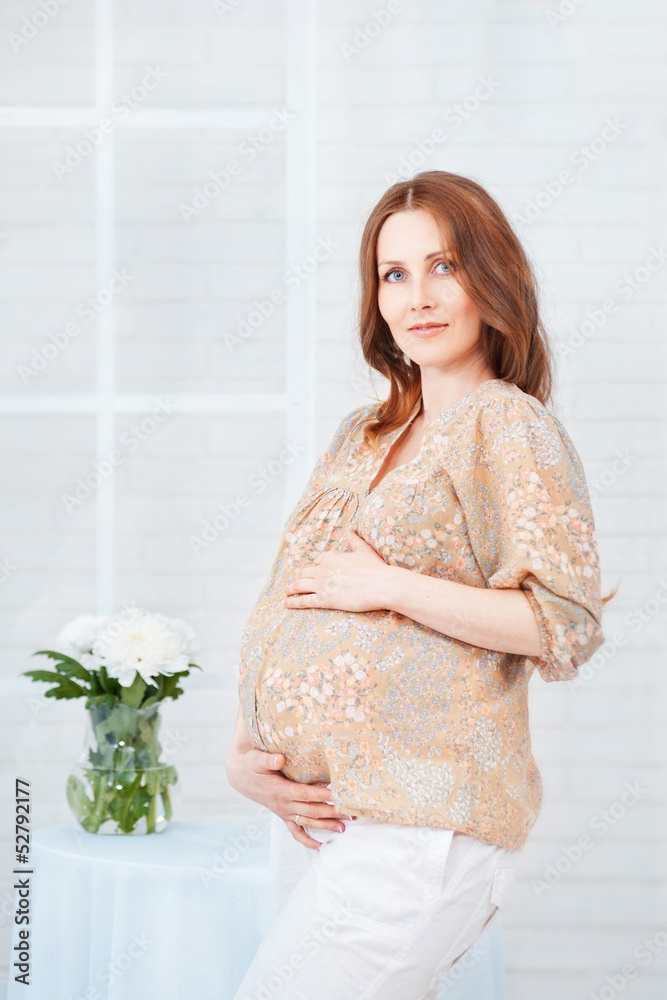 Pregnant woman in white room