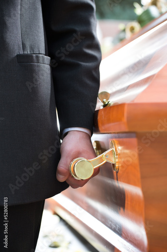 Valokuva coffin bearer carrying casket at funeral