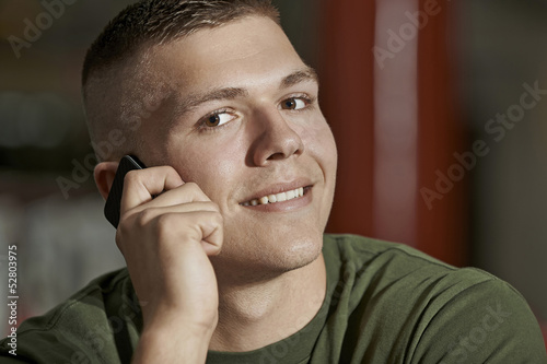 Young man talking on smartphone and smiles