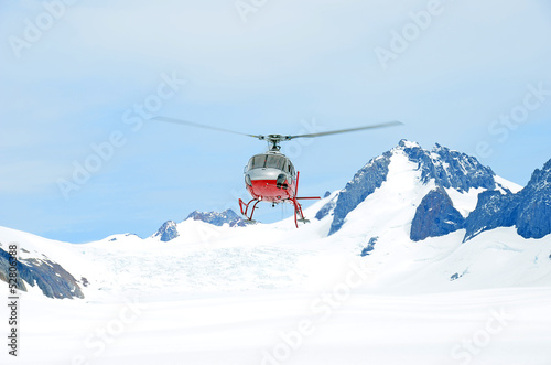 Helicopter taking off from the snow photo