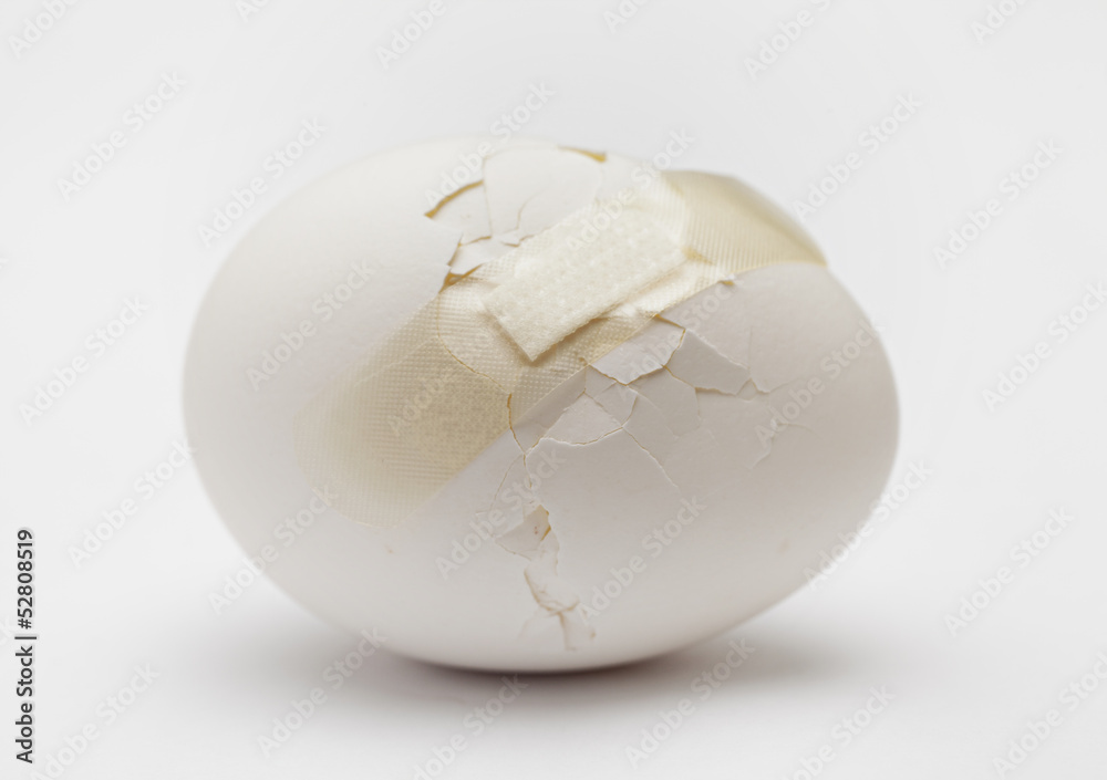 Cracked white egg with plastic plaster