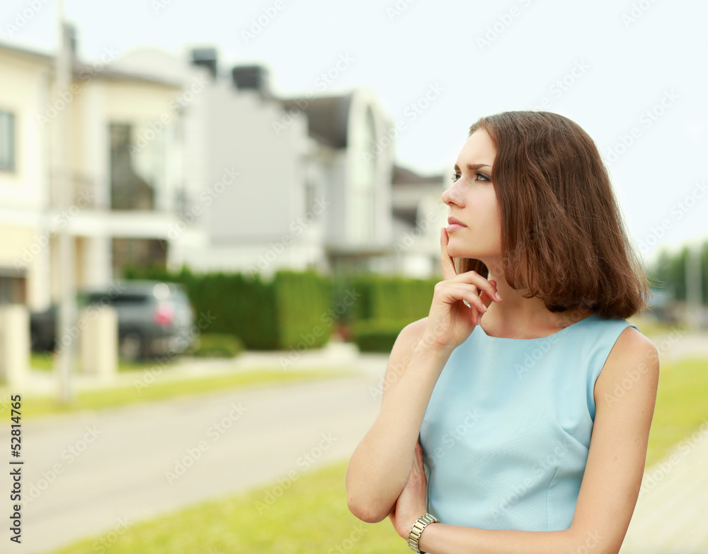 Fototapeta premium Young woman standing near house