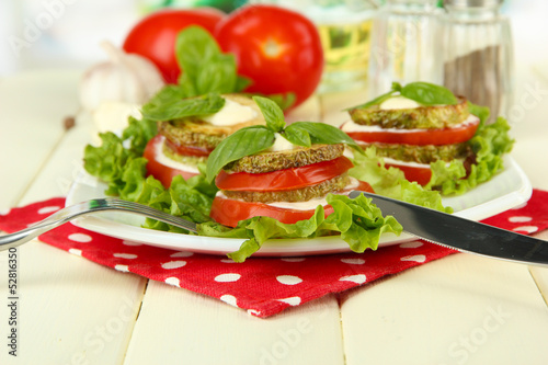Tasty roasted marrow and tomato slices with salad leaves,