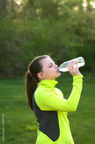 An image of a young girl drinking from a water bottle