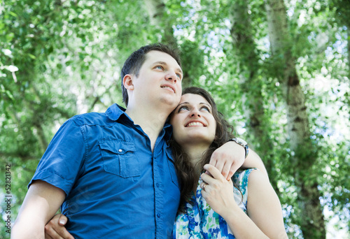 happy middle-age couple in park looking up with hope