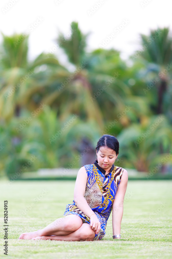 Asian woman sit on ground in park