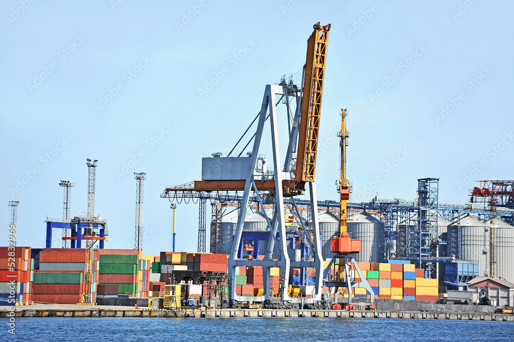 Port cargo crane and container over blue sky background