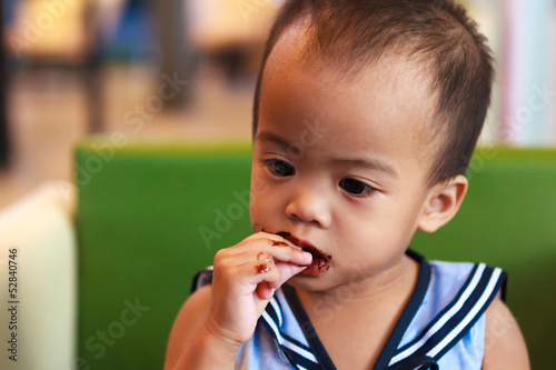 Asian baby girl eating chocolate