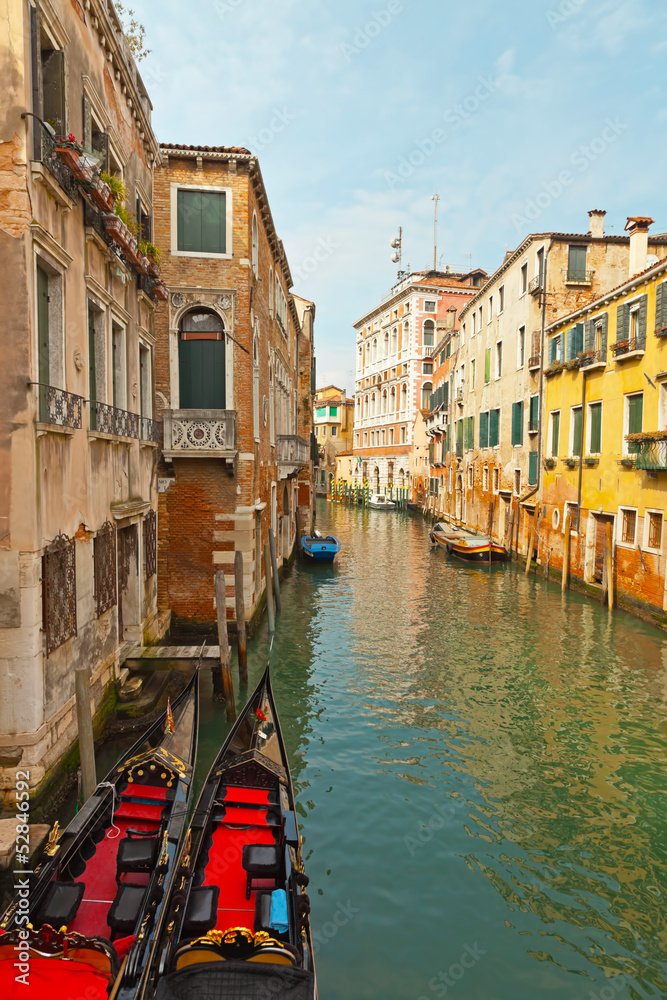 Venetian canals with houses and two gondola boats. Venice. Italy