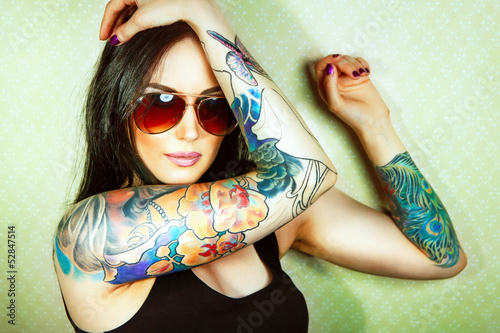 Beautiful girl with stylish make-up and tattooed arms..