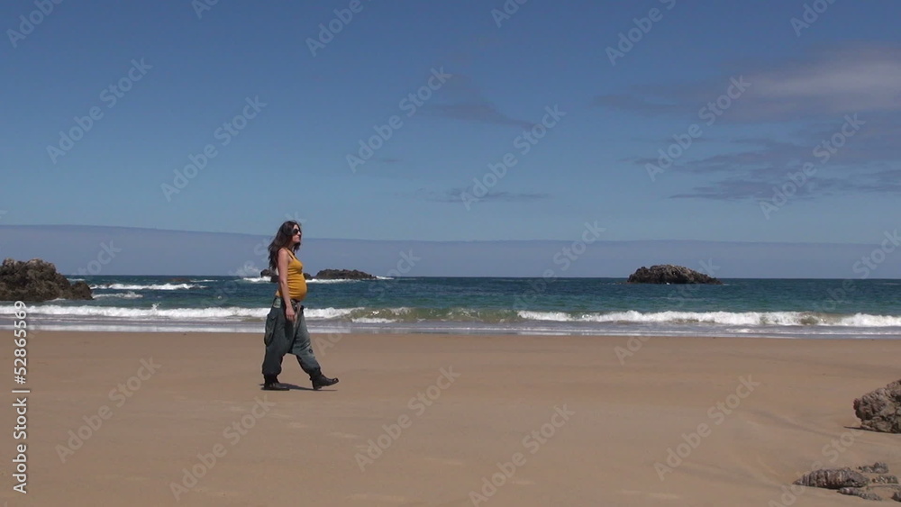 pregnant woman walking at beach pregnant woman walking at beach
