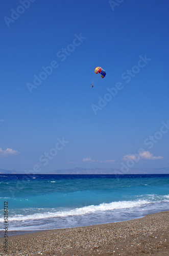 Parasailing over the sea on the sunny day
