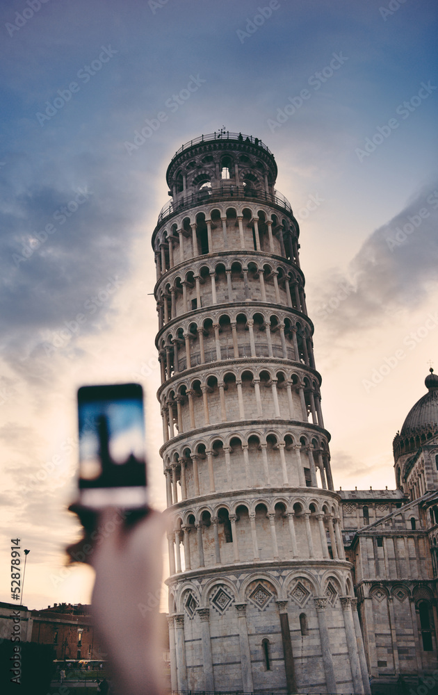 Tourist taking a photo at the Pisa Tower with a smartphone