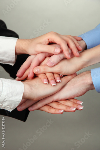 Group of young people s hands on gray background