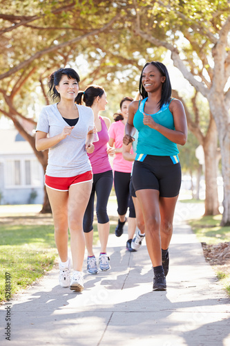 Group Of Female Runners Exercising On Suburban Street
