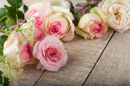 Fresh roses on wooden background