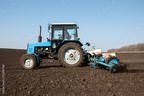 Tractor with sower on the field