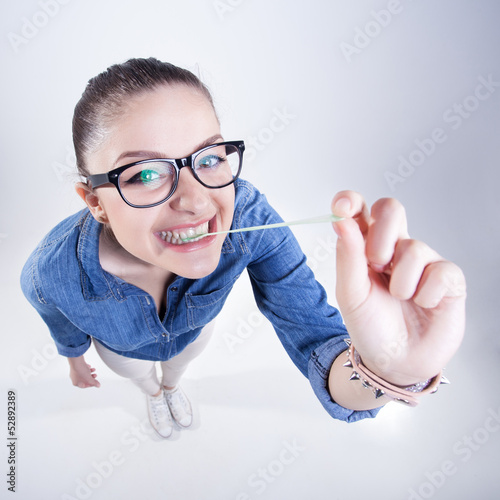 girl with perfect teeth smiling and playing with chuwing gum photo