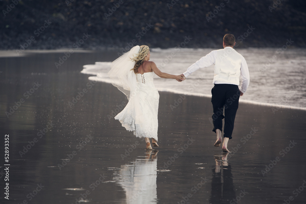 Newlyweds holding hands to go along the ocean shore. Newlyweds holding hands to go along the ocean shore.