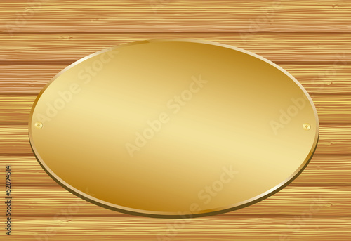Golden plate on wooden background.