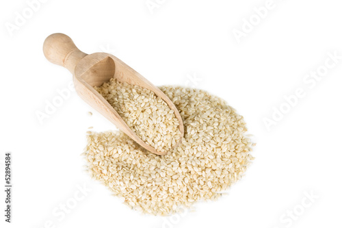Sesame seeds in a spoon for spices isolated on a white backgroun