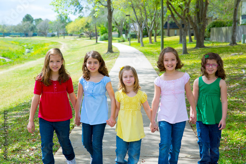 Children group of sisters girls and friends walking in park