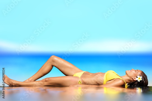 Sunbathing woman relaxing under sun in luxury