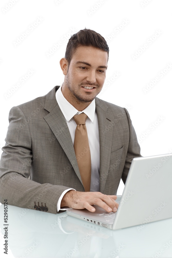 Happy businessman working on laptop