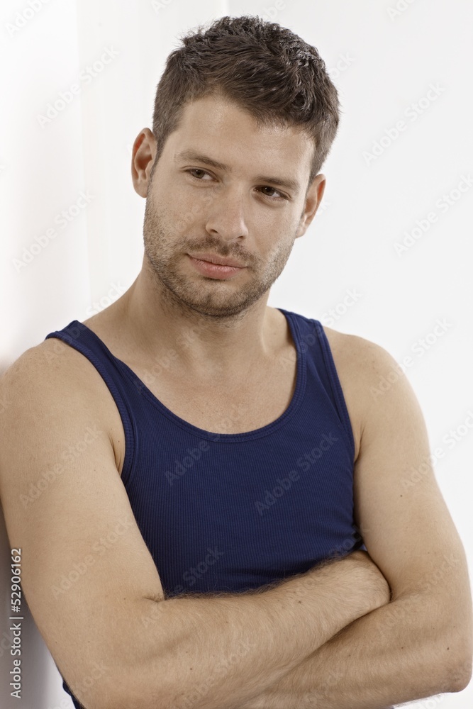 Young man in vest standing arms crossed Young man in vest standing arms crossed
