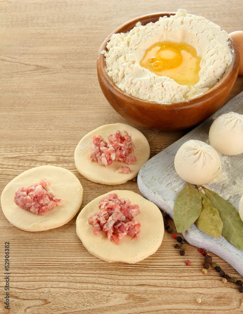 Raw dumplings, ingredients and dough, on wooden table