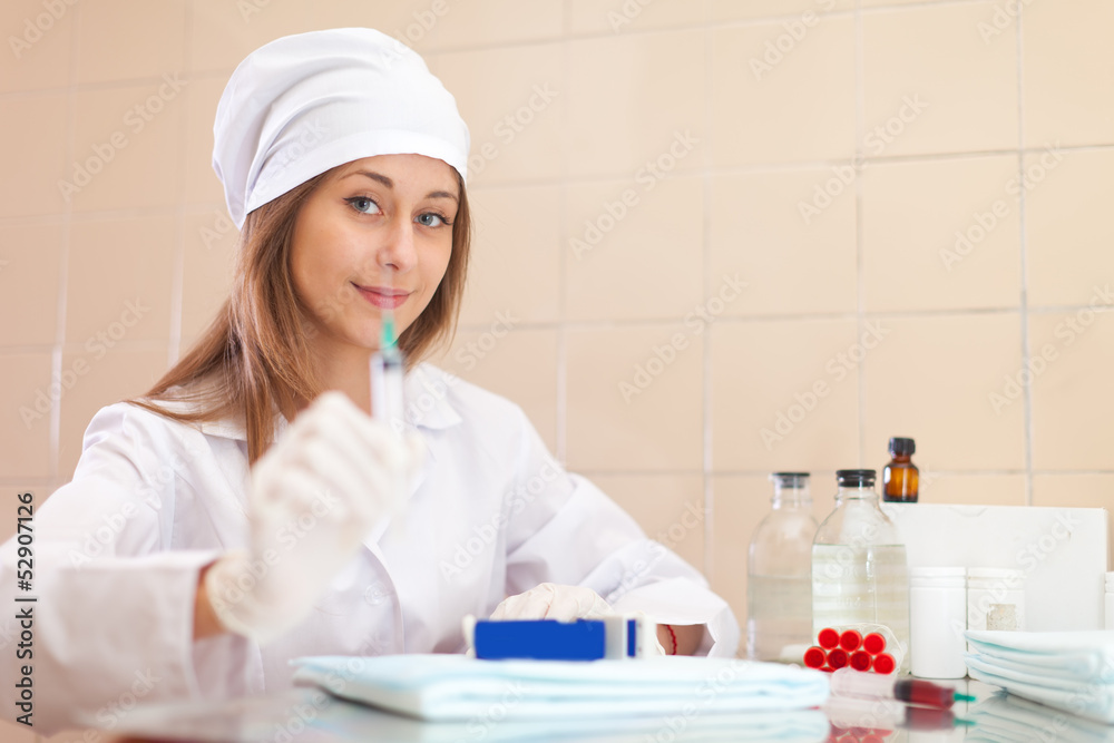 Positive young nurse with syringe