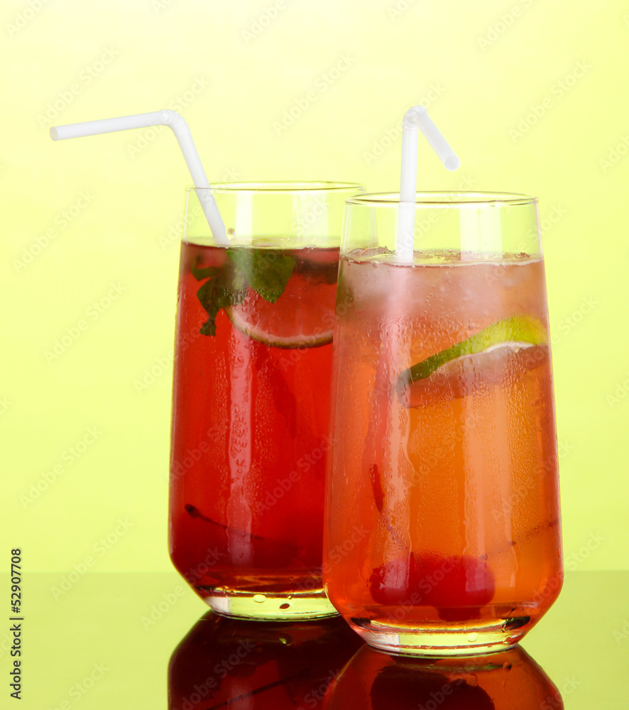 Two cherry cocktails with ice on green background Two cherry cocktails with ice on green background