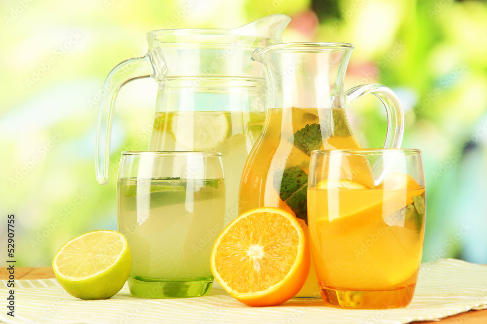 Orange and lemon lemonade in pitchers and glasses Orange and lemon lemonade in pitchers and glasses