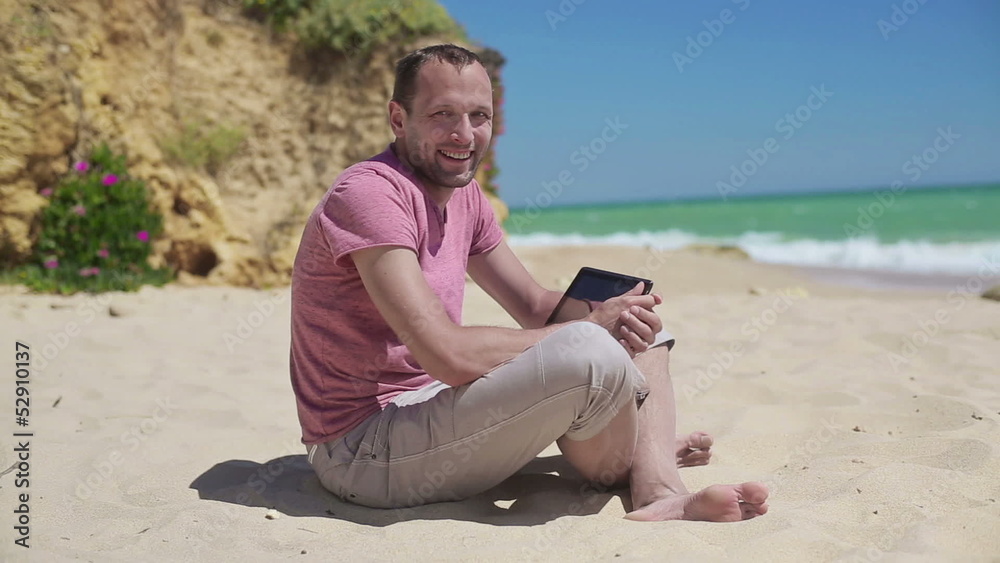 Happy young man with tablet computer on the beach Happy young man with tablet computer on the beach