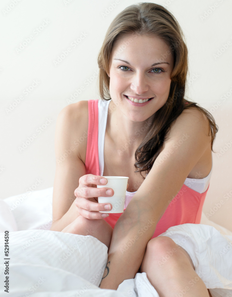 Junge, sportliche Frau trinkt Wasser zum Frühstück im Bett Junge, sportliche Frau trinkt Wasser zum Frühstück im Bett