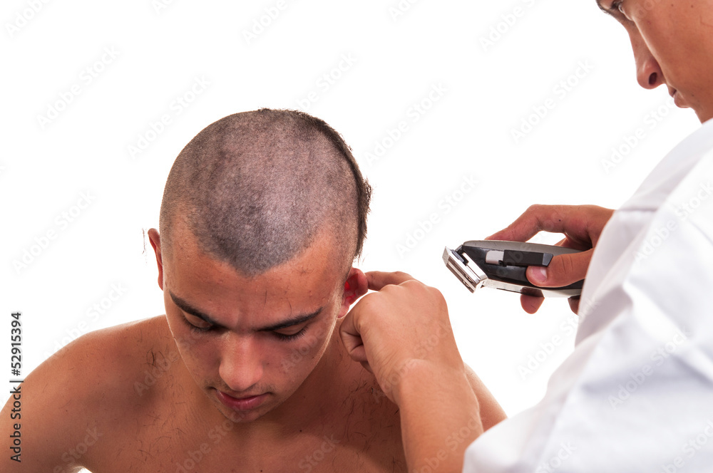 Fototapeta premium Barber cutting hair with clipper on white background