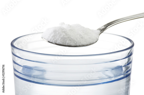 Spoon of baking soda over glass of water