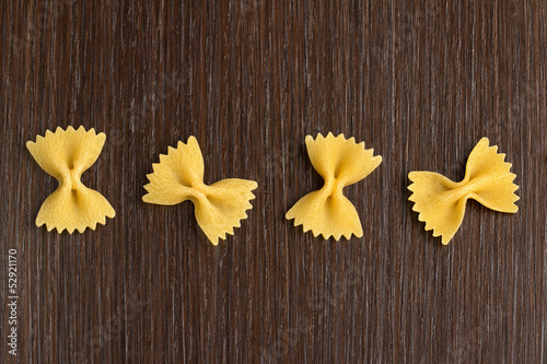 four bow tie pasta on wooden background