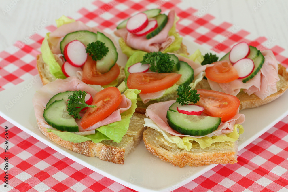 Sandwiches with ham and salad on checkered napkin Sandwiches with ham and salad on checkered napkin