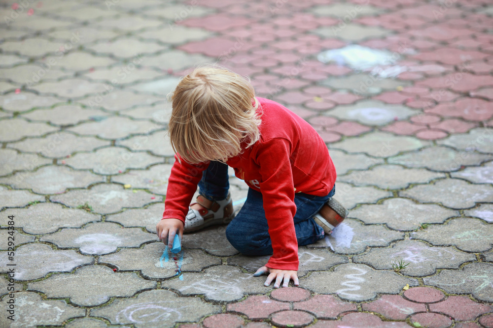 Preschooler child drawing with chalk on sidewalk Preschooler child drawing with chalk on sidewalk